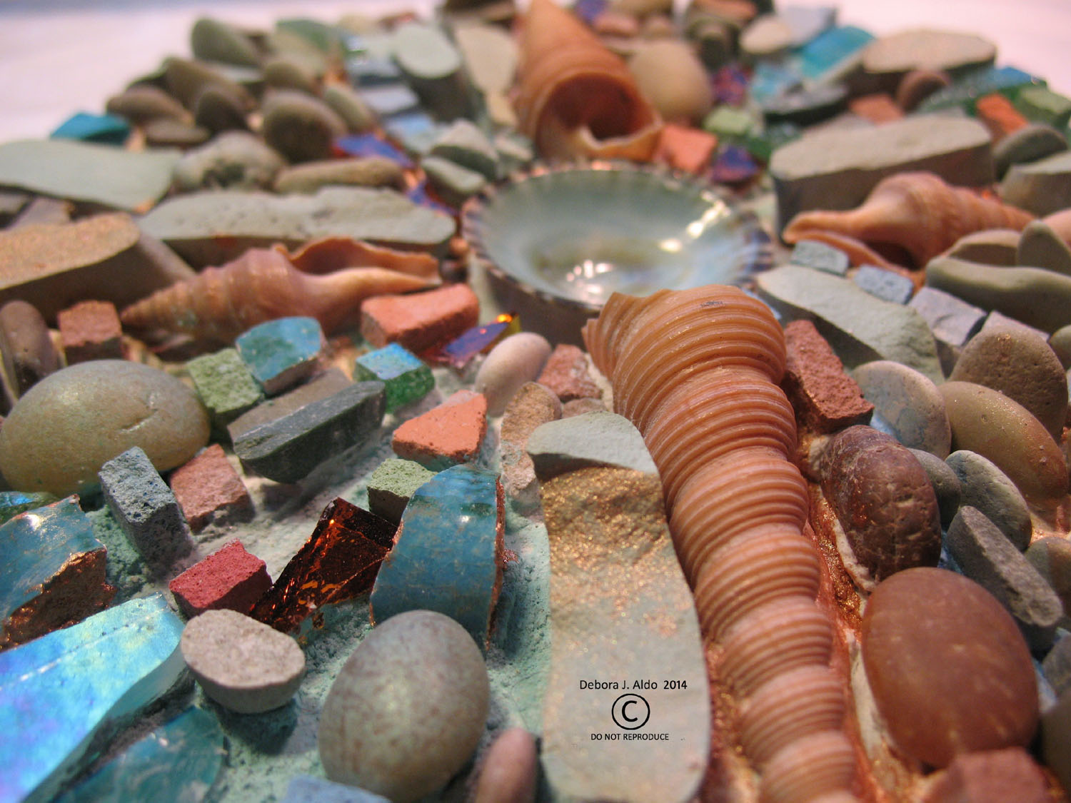 Pebbles, Rusted discarded hardware, shells, colored thinset.